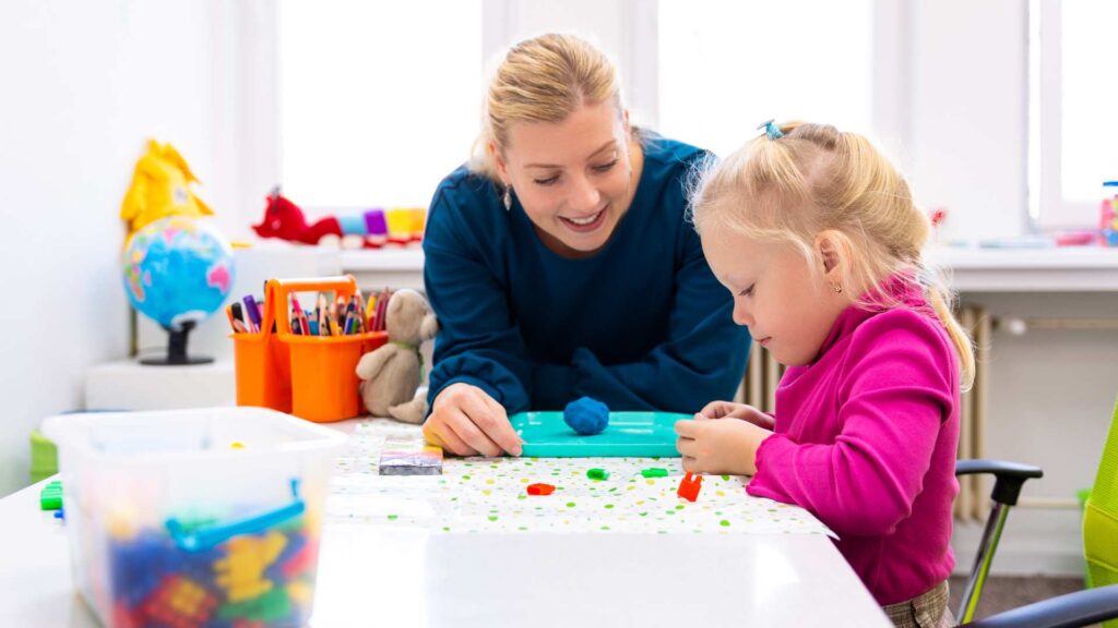 a woman and a child playing with colorful clay