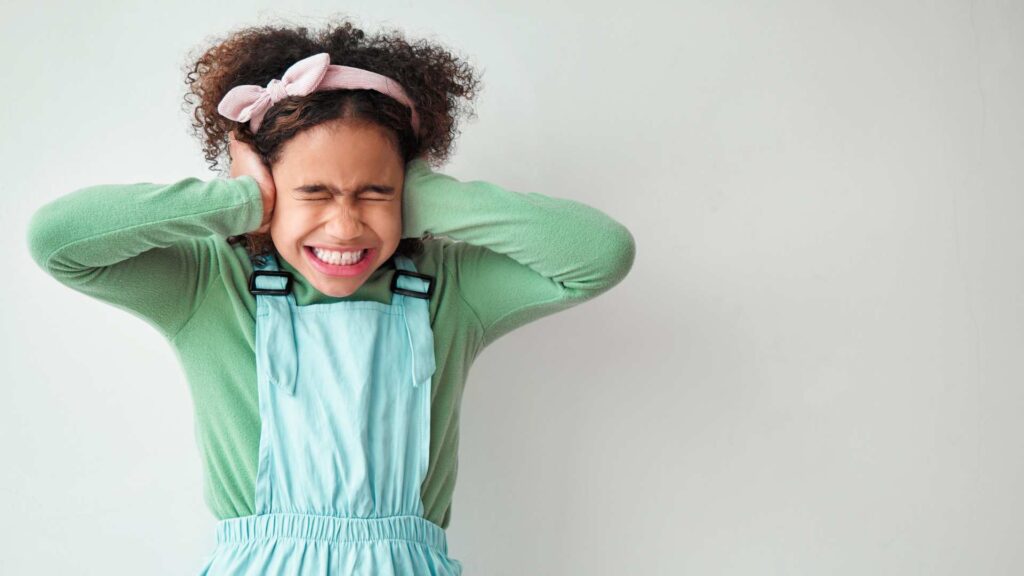 a girl covering her ears with her hands