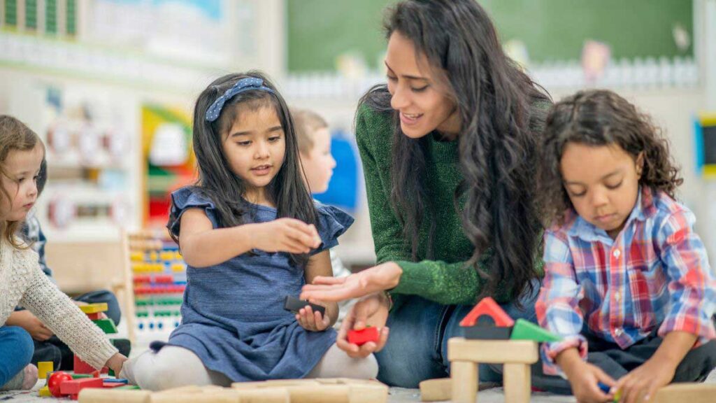 A Board Certified Behavior Analyst works with children as they play with blocks